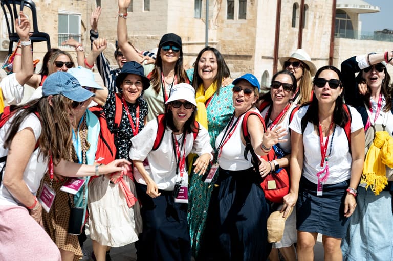 A large group cheering with raised arms on a Jerusalem street