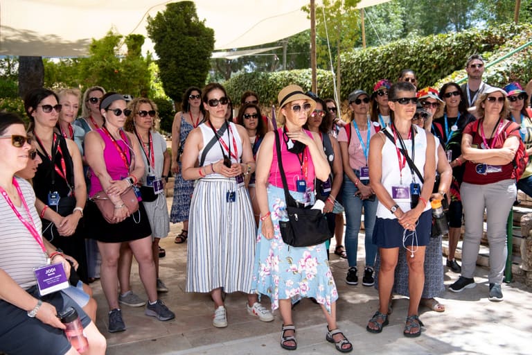 The group listening together under shade sails in a Jerusalem garden